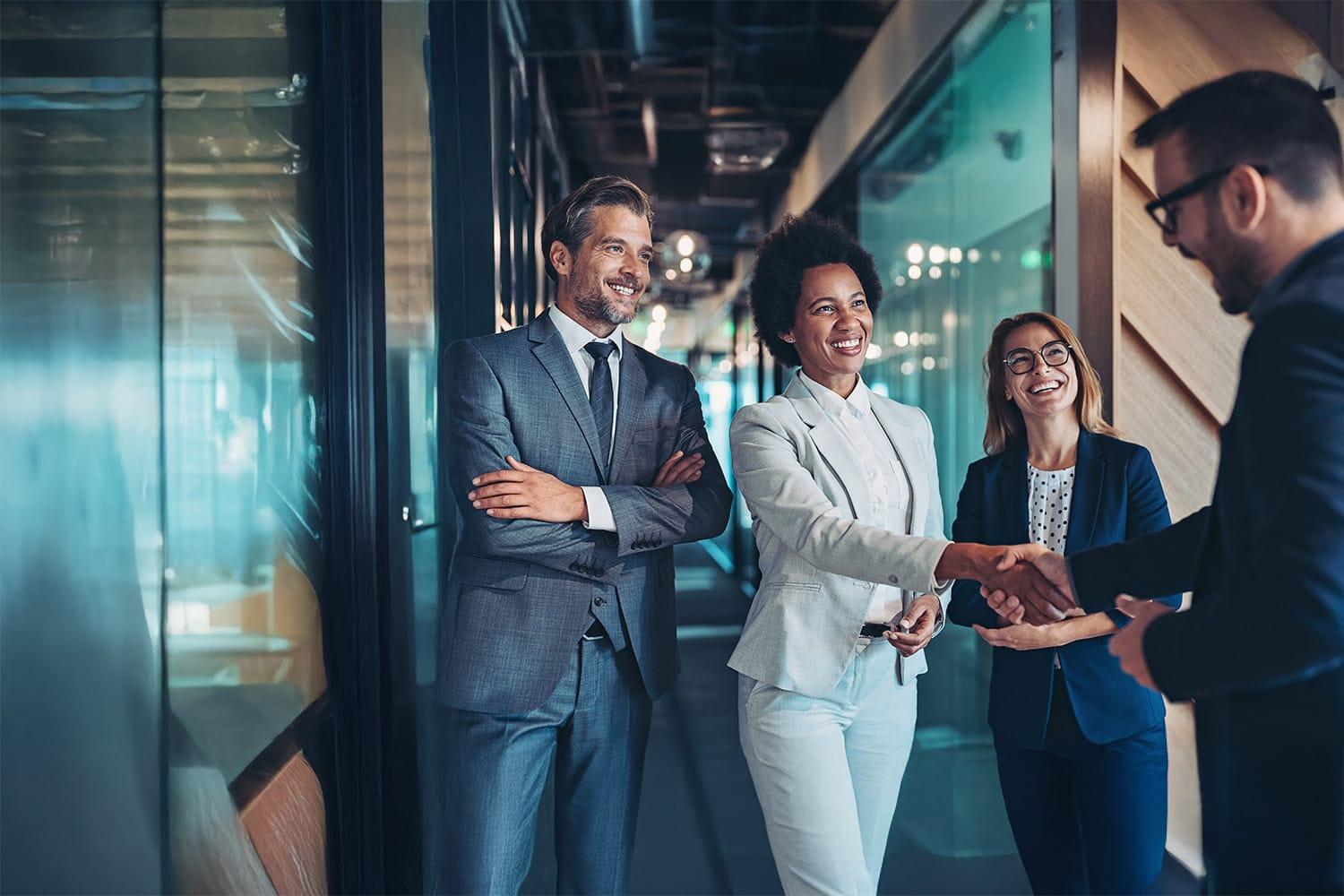 Small group of smiling business people shaking hands in the office Small group of smiling business people shaking hands in the office